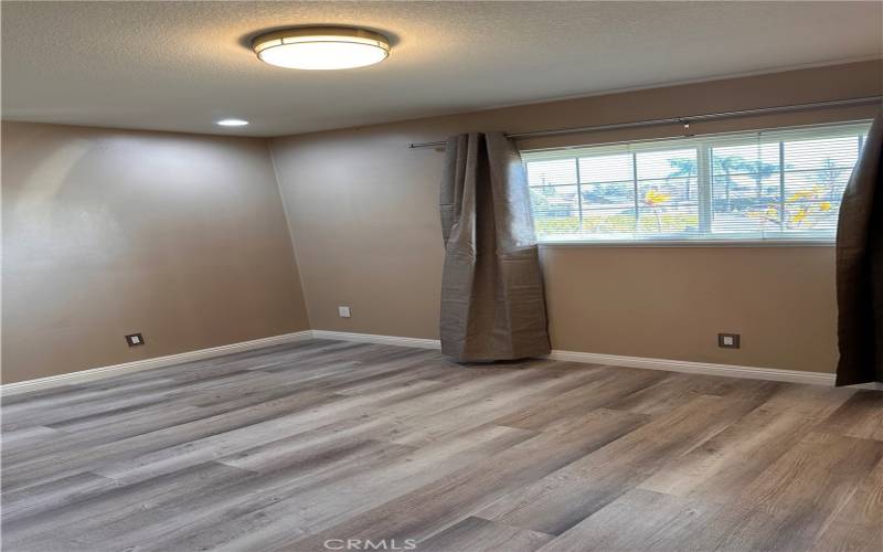 First bedroom with recess lighting and ceiling light.