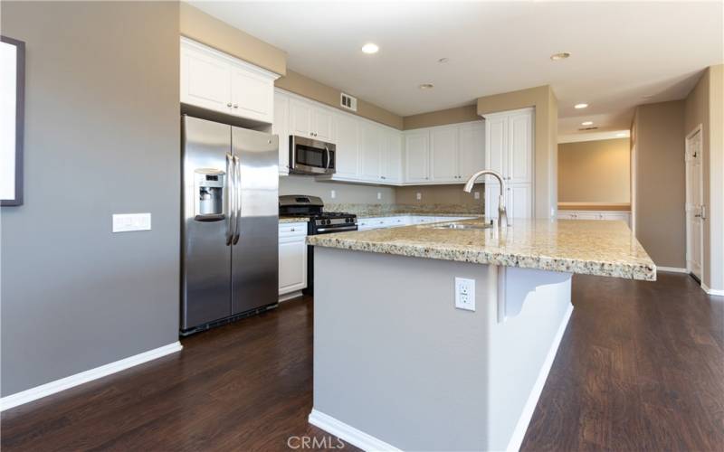 Granite counters and white cabinetry in kitchen.