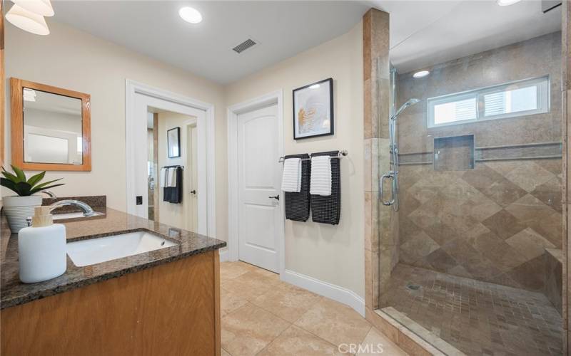 Primary bath is luxuriously appointed with spacious shower and bench seating and dual vanity sinks.