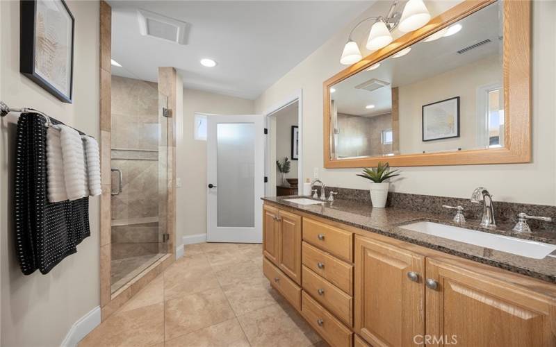 Freshly remodeled primary bath has spacious walk in shower with glass enclosure. Dual vanity sinks with granite counters which means there is plenty of space for getting ready each day.