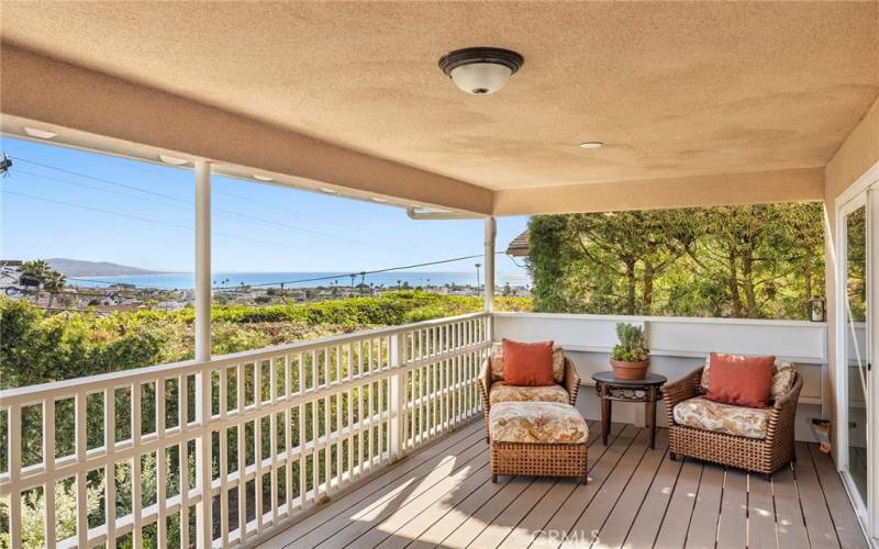 Adjacent to the living room, the large outdoor patio with a wood cover offers the perfect space to unwind and take in spectacular sunsets over the Pacific.