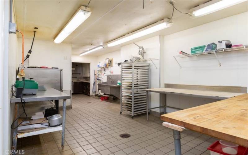 Large prep area, plenty of room for more equipment, 220V electric power, floor drains, 3 compartment stainless steel sink with plumbing available for a dishwashing station